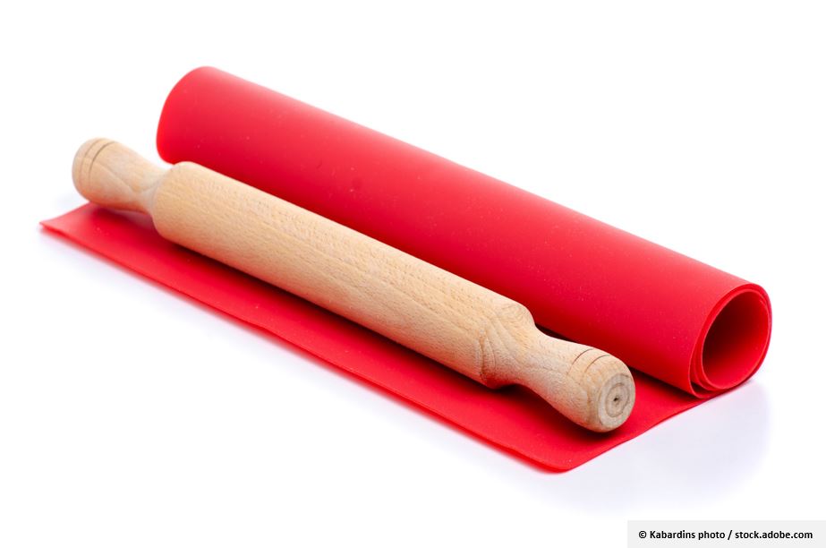Eine Backmatte mit einem Rollholz zum Hundekekse zu backen.