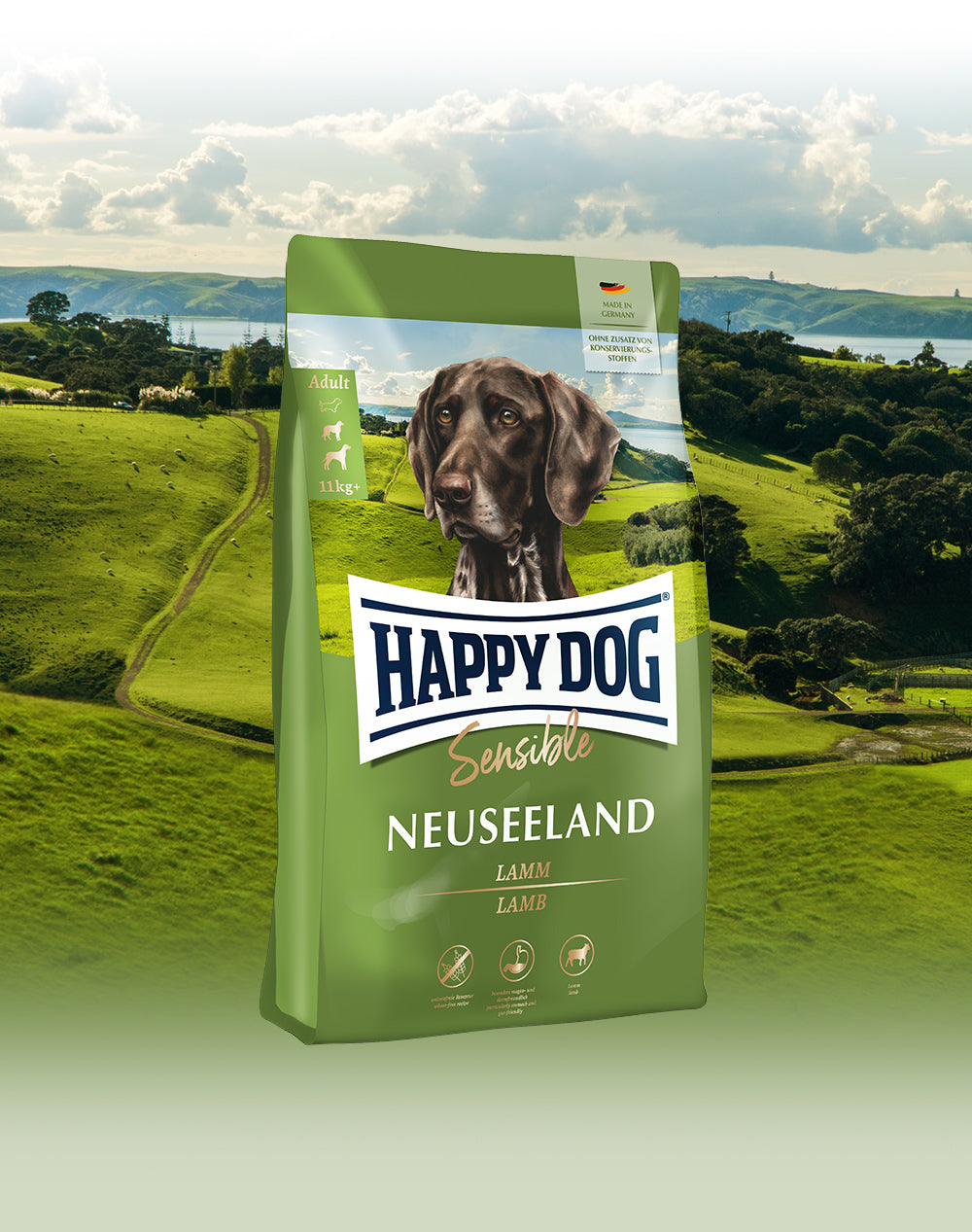 Das Hundefutter Happy Dog Sensible Neuseeland vor einer weiten, grünen Landschaft, die typisch für Neuseeland ist.