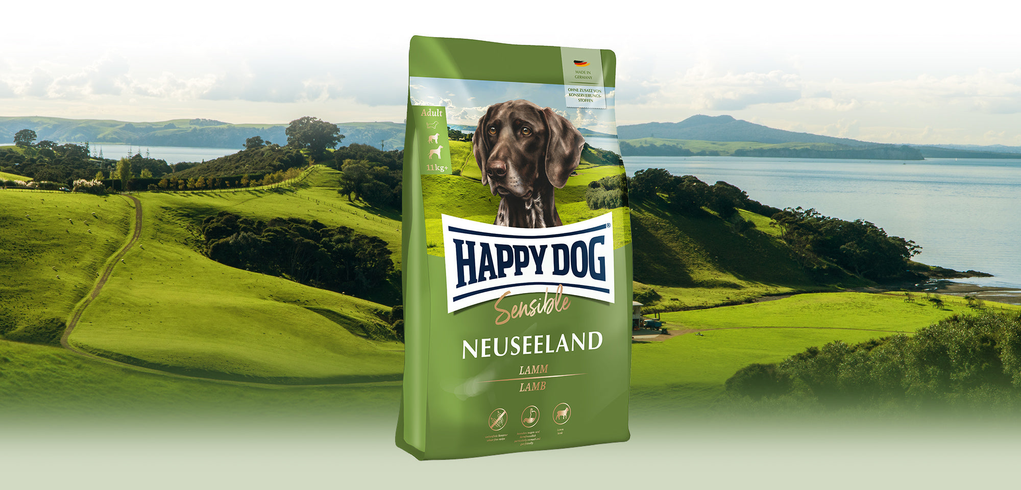 Das Hundefutter Happy Dog Sensible Neuseeland vor einer weiten, grünen Landschaft, die typisch für Neuseeland ist.